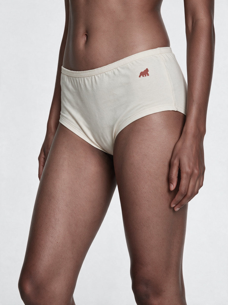 Woman wearing a midi dress with undyed cotton boy shorts underneath for comfortable coverage