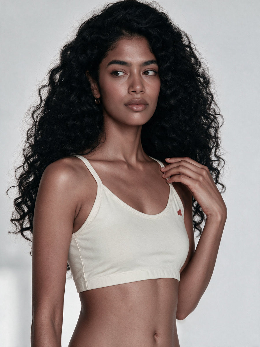 Fit-guide flat-lay of an organic cotton training bra with a soft tape measure