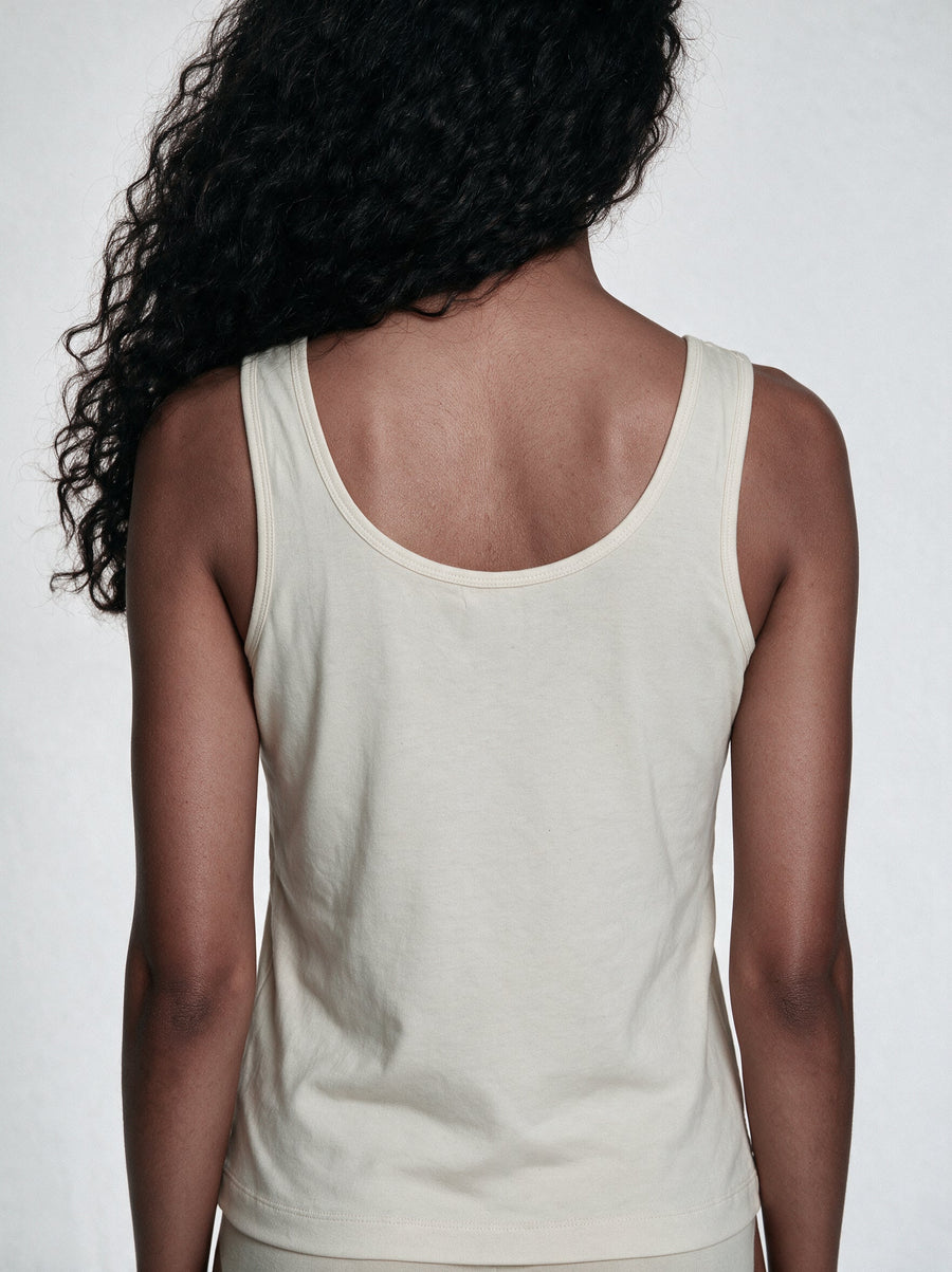 Un-dyed organic cotton camisole air-drying flat on a rack after a gentle wash